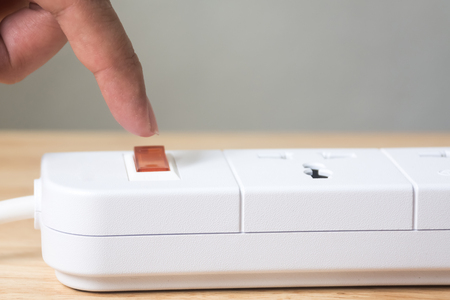 Hand of male or female pressing button power switch off to save energy, Reduce energy efficiency...