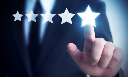 Businessman hand touching five star symbol to increase rating of company concept, Copy space background for your titleの写真素材