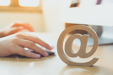 Email marketing concept, Hand using computer sending message with wooden email address symbol