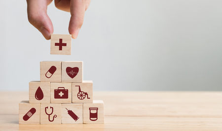 Hand arranging wood block stacking with icon healthcare medical, Insurance for your health conceptの写真素材