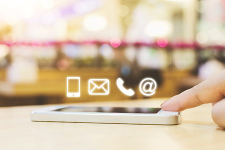 Woman hand pushing button smartphone, Business connection contact us concept, Icon mobile phone, email, telephone and e-mail addressの写真素材