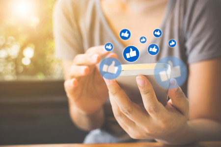 Social network sharing and commenting in the online community, Woman hand holding smartphone and using application social mediaの写真素材