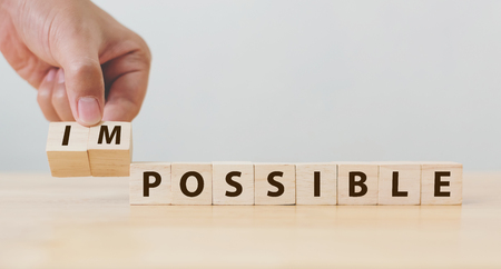 Hand flip wooden cube with word impossible to possible, Personal development and career growth or change yourself conceptの写真素材