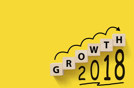 Business success growing growth increase up concept. Wooded cube block on yellow background with word GROWTH and 2018, Copy space for your textの写真素材