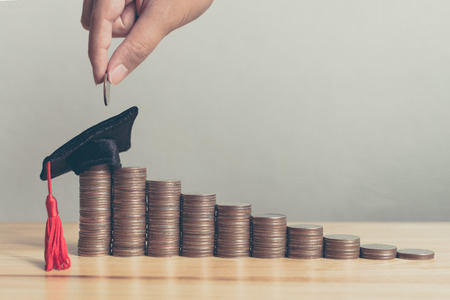 Scholarship money concept. Hand of male or female putting coins on stack step growing growth saving money investmentの写真素材