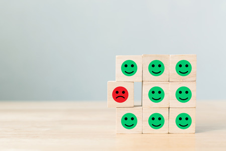 Wooden block with icon face emotion happiness and sadness, Unique, think different, individual and standing out from the crowd conceptの写真素材