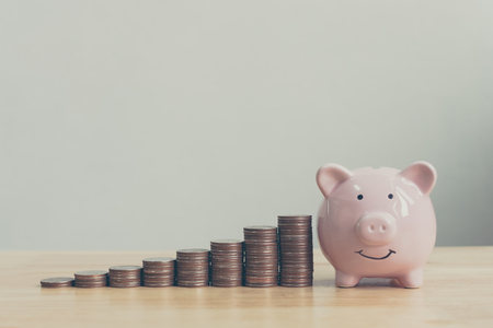 Piggy bank pink colour with money stack step up growing growth saving money, Concept financial business investment. Copy space for your textの写真素材