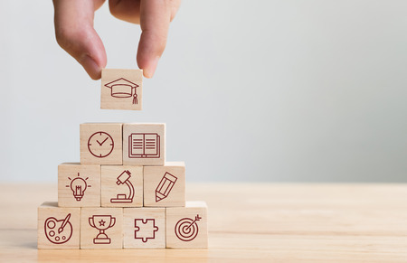 Hand arranging wood block stacking with elements education icon. Diagram of knowledge graduation conceptの写真素材