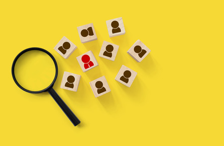 Human resource and talent management and recruitment business building team, Personal development of employee in organization. Wood cube block on yellow background with magnifying glassの写真素材