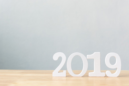 Happy new year 2019, Number wood material on wooden table with white wall background, Copy space
