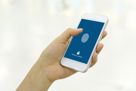 Hand holding smartphone and scan fingerprint biometric identity for unlock her mobile phoneの写真素材