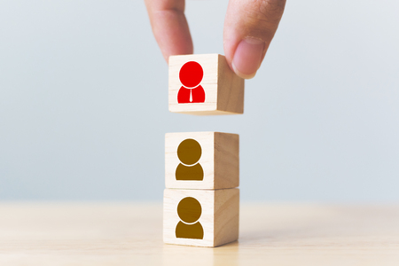 Human resources management and recruitment business build team concept. Hand putting wood cube block on top with iconの写真素材