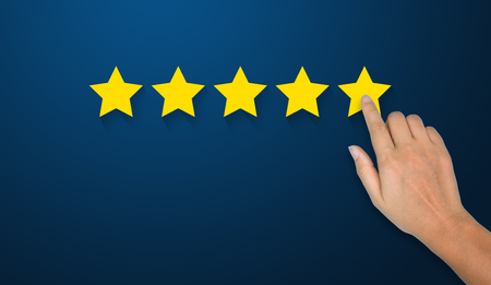 Hand of businessman touching five star symbol to increase rating of company concept, Copy space background for your titleの写真素材