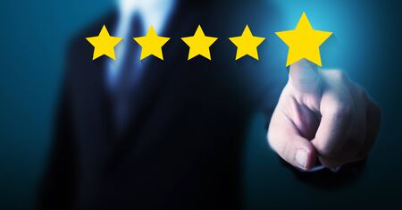 Hand of businessman touching five star symbol to increase rating of company concept