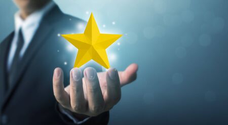 Businessman hands hold a five-star gold shape. The best excellent business services rating customer...