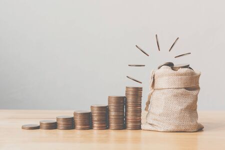 Coins drop on top in money bag with coin stack step growing growth saving money. Concept finance...