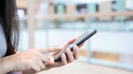 Close up image hand of woman using mobile smart phone in the mallの写真素材