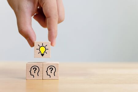 Concept creative idea and innovation. Hand choose a wooden cube block with light bulb and head human...