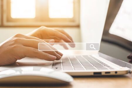 Searching information data on internet networking concept. Hand of male typing text on laptop keyboardの写真素材