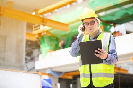 Young asian engineers are working on the construction site. Wear a yellow helmet safety and uniform...