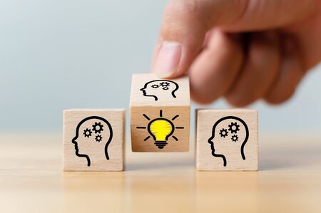 Concept creative idea and innovation. Hand flip over wooden cube block with head human symbol and...