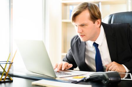 Young business man are busy working in the office. He using laptop on desk in office roomの写真素材