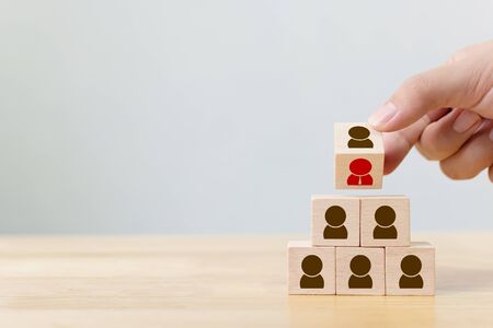 Human resource management and recruitment business concept, Hand flip over wood cube block on top pyramid, Copy spaceの写真素材