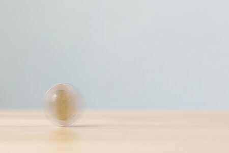 Coin spin on wooden desk table. Save money and financial investment conceptの写真素材