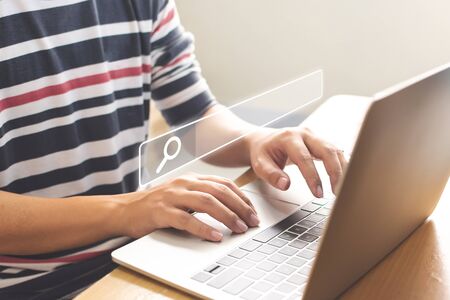 Searching information data on internet networking concept. Hand of male typing text on laptop keyboardの写真素材