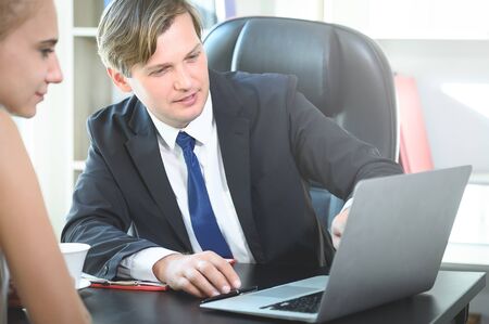 Positive business people watching laptop conference webinar together preparing corporate project using modern technology and wifi networkingの写真素材