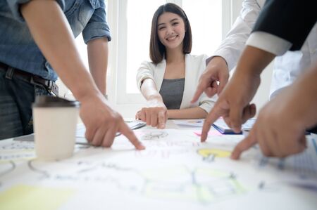 Beautiful young asian businesswoman are meeting their teammates and paperwork document on deskの写真素材