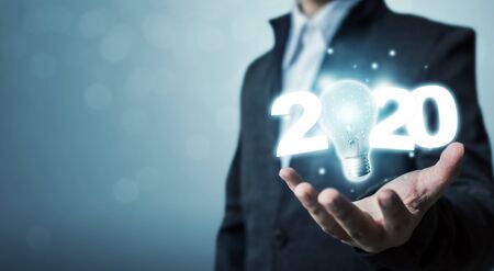 Businessman hand holding light bulb with year 2020 idea innovation technology conceptの写真素材