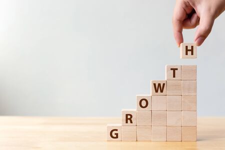 Ladder career path for business growth success process concept.Hand arranging wood block stacking as step stair with word GROWTHの写真素材