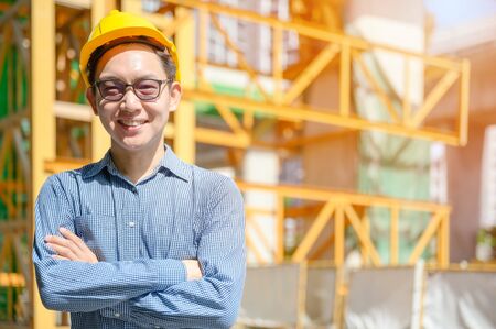 New generation of asian engineers are working on the construction site. He looks handsome and smart.の写真素材