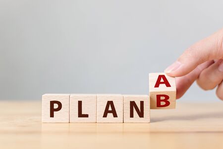 Hand flip over wooden cube block word plan A to plan Bの写真素材