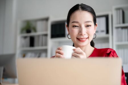 Work from home concept, Portrait of beautiful young asian woman working on laptop in workplaceの写真素材