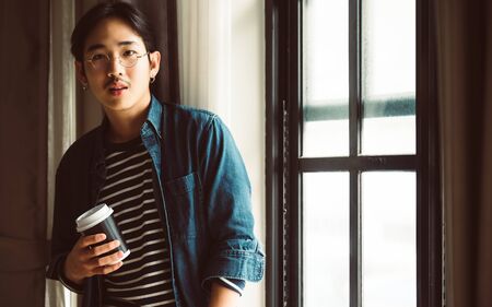 Portrait asian man business startup. He is young entrepreneur generation y and relax standing inside...