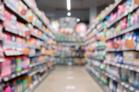 Abstract blurred supermarket aisle with colorful shelves and product consumer on shelf as backgroundの写真素材