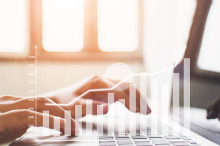 Hand using computer laptop analyzing sales data and economic growth graph chart. Business strategy development to success and growing concept. Digital marketingの写真素材