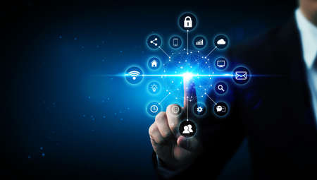 Internet of things (IOT) concept. Businessman touching solution represented by symbol connected with...