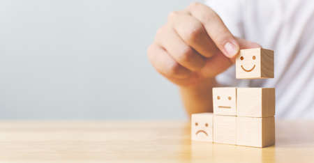 Hand chooses smiley face growth on wood block cube, The best excellent business services rating...