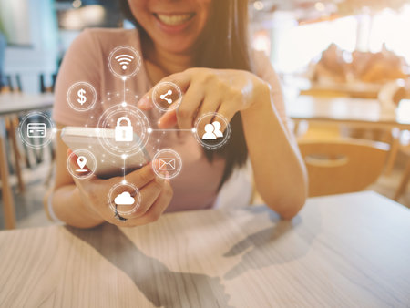 Young woman smiling and using smartphone and with icon graphic symbol cyber security network protection of connection devices and secure personal data in mobile phonesの写真素材