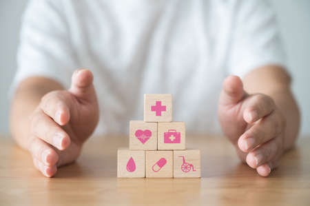 Hand protect wood block stacking with icon healthcare medical, Insurance for your health conceptの写真素材