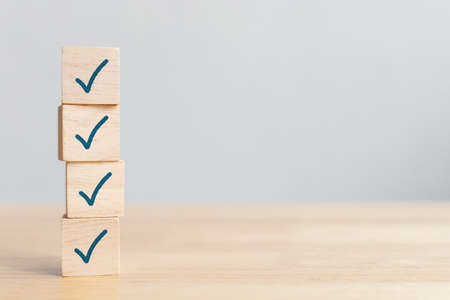 Checklist concept, Check mark on wooden blocks on table with copy space
