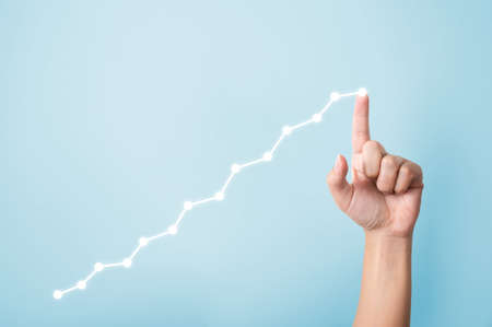 Growth business concept. Hand pointing increase graph moving up and copy spaceの写真素材