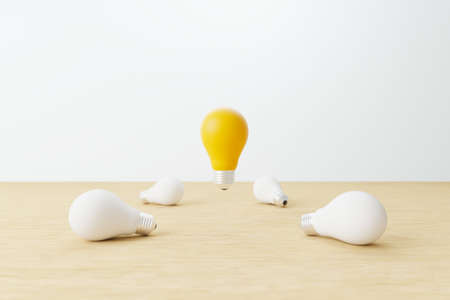 Light bulb yellow floating outstanding among white lightbulb on wood table. Concept of creative idea and innovation, Unique, Think different, Individual and standing out from the crowd. 3d render illustrationの写真素材