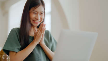 Excited asian female feeling euphoric celebrating online win success achievement result, young woman happy about good email news, motivated by great offer or new opportunity, passed exam, got a jobの写真素材