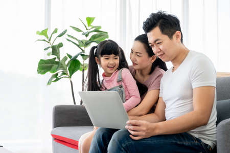 Happy asian family playing together at home in living room