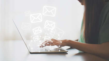 Email marketing and newsletter concept. Hand of woman using computer laptop and sending online message with email iconの写真素材