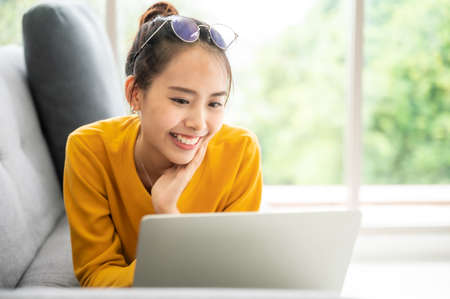 Young asian woman using laptop at house. Work at home, Video conference, Online meeting video call, Virtual meetings, Remote learning, E-learning and Online Educationの写真素材